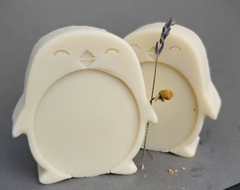 May include: Two white penguin-shaped soaps with a dried lavender sprig between them.