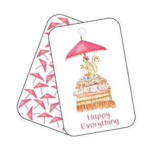 May include: A white gift tag with a pink and white monkey sitting on a stack of pillows under a pink umbrella. The tag says "Happy Everything" in pink lettering.