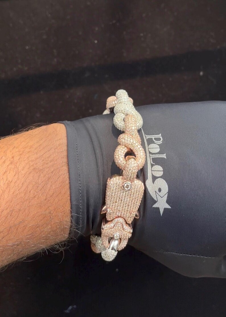 Peut inclure: Un bracelet bicolore avec une finition or rose et argent. Le bracelet pr&eacute;sente un design de maillons unique et est incrust&eacute; de petites pierres scintillantes. Le fermoir est &eacute;galement orn&eacute; de pierres.