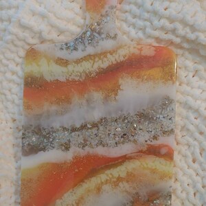 decorative paddle shaped board multiuse; charcuterie, appetizers, trinkets etc.orange,gold,white, yellow