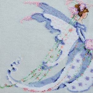 May include: A cross-stitch embroidery of a fairy with blue wings and a white dress with pink flowers. The fairy is holding a bouquet of pink flowers.