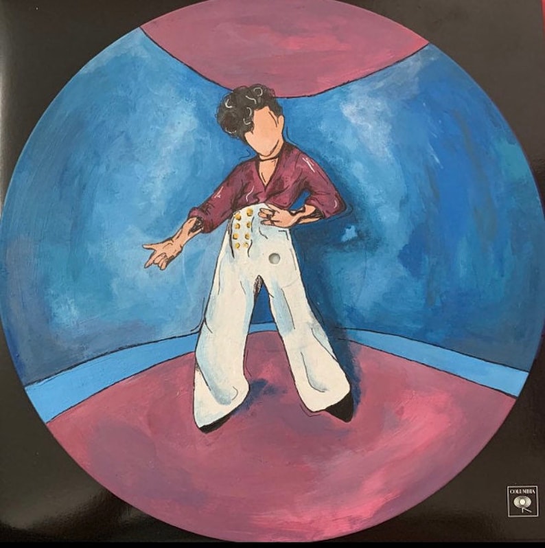 May include: A circular vinyl record featuring a hand-painted illustration of a figure with dark curly hair, wearing a maroon long-sleeve shirt and high-waisted white trousers with gold buttons. The background is a blue and pink room.