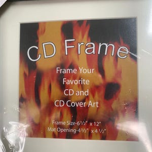 May include: Black CD frame with a white mat. The frame has the text "CD Frame" and "Frame Your Favorite CD and CD Cover Art". The frame size is 6.5" x 12" with a mat opening of 4.5" x 4.5".