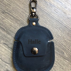 May include: A dark blue leather case with a silver clasp and a metal button. The case has a blue stitching detail and the name "Halle" is engraved on the front.