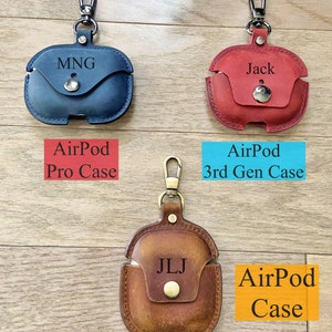 May include: Three leather AirPod cases with personalized initials and a metal carabiner. The cases are blue, red, and brown. The text on the cases reads "AirPod Pro Case", "AirPod 3rd Gen Case", and "AirPod Case".
