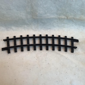 May include: A curved section of black plastic toy train track. The track has evenly spaced vertical supports connecting two parallel rails. The track is designed to allow a toy train to navigate a curve.