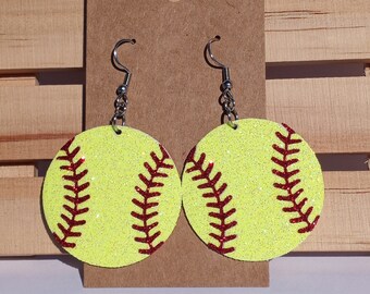 Peut inclure: Une paire de boucles d'oreilles en forme de balle de softball jaune et rouge à paillettes avec des crochets argentés.