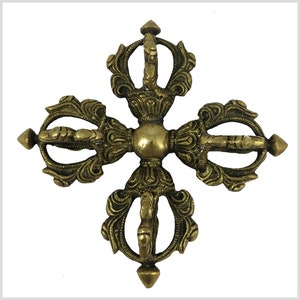 Puede incluir: Una rueda de oración tibetana de metal dorado con diseños intrincados y cuatro radios. La rueda es un símbolo budista tradicional de la oración y la meditación.