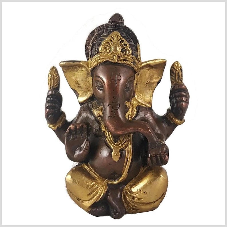 K&ouml;nnte beinhalten: Eine goldene und braune Ganesha-Statue mit einer goldenen Krone und einem R&uuml;ssel, der sich nach links kr&uuml;mmt. Die Statue sitzt mit gekreuzten Beinen und den H&auml;nden in Mudra.
