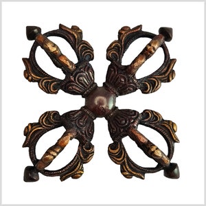 Peut inclure: Un vajra à quatre bras, un objet rituel bouddhiste tibétain traditionnel, en métal avec une finition brun foncé et dorée. Le vajra est un symbole de force, de pouvoir et d'illumination.