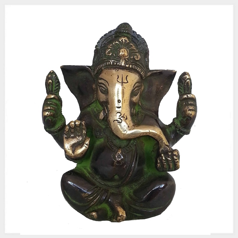 K&ouml;nnte beinhalten: Eine gr&uuml;ne und goldene Messingstatue von Ganesha, dem hinduistischen Gott der Weisheit und des Wohlstands. Die Statue zeigt Ganesha sitzend mit erhobenem R&uuml;ssel und seinen H&auml;nden in einer Mudra. Er tr&auml;gt eine Krone und eine Halskette.