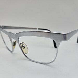 May include: Silver-toned metal eyeglasses with a cat-eye frame and clear lenses.