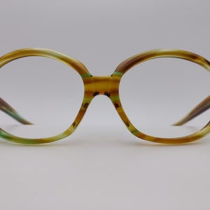 Peut inclure: Lunettes rondes, brunes et vertes avec un motif en écaille de tortue.