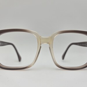 May include: Brown and beige plastic framed eyeglasses with square lenses.