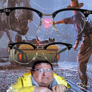 May include: Black and silver-rimmed eyeglasses with a classic design. The glasses are set against a movie scene backdrop featuring a dinosaur and a person in a hat. The image includes a person wearing glasses and a yellow raincoat.