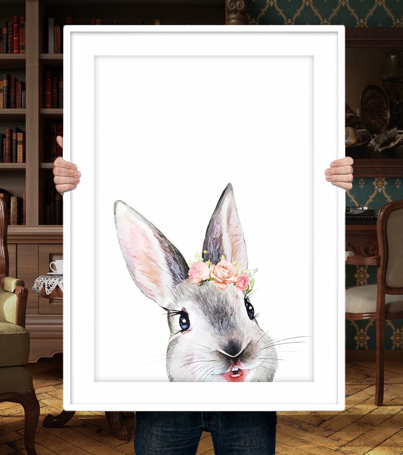Puede incluir: Una pintura de acuarela de un conejo gris con flores rosas en las orejas. El conejo est&aacute; mirando directamente al espectador con una expresi&oacute;n juguetona.