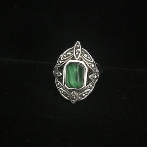 Op de afbeelding: Een zilveren ring met een groene malachiet-steen gezet in een filigraan ontwerp.