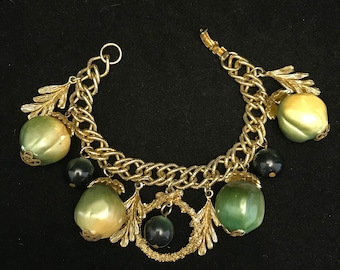 Pulsera vintage con dije de fruta artificial: plástico termoestable en tono dorado y verde.