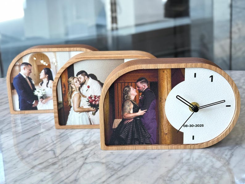 May include: Three semi-circular wooden desk clocks featuring custom photo prints of couples. The front-most clock displays a photo of a couple, a white circular clock face with black hands, and the printed date 08-30-2025 on the white surface.