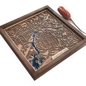 Puede incluir: Un mapa de madera de Waltham, MA, con un río y un lago de resina azul. El mapa está enmarcado en un marco de madera oscura.