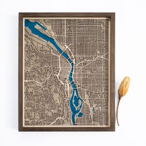 A wooden map of your favourite place enclosed in a wooden frame. It has 3D city streets and epoxy resin water. By adding a pin in a important place for you and an engraving you will make a personalized gift.