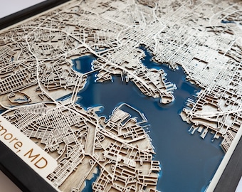 Puede incluir: Un mapa de madera de Baltimore, MD con una incrustación de resina epoxi azul. El mapa está enmarcado en negro y presenta contornos de calles detallados.