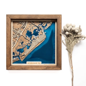A wooden map of your favourite place enclosed in a wooden frame. It has 3D city streets and epoxy resin water. By adding a pin in a important place for you and an engraving you will make a personalized gift.