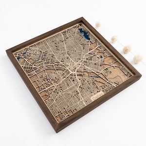 A wooden map of your favourite place enclosed in a wooden frame. It has 3D city streets and epoxy resin water. By adding a pin in a important place for you and an engraving you will make a personalized gift.