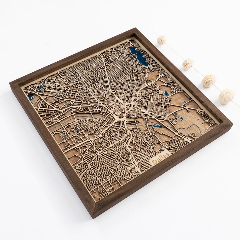 A wooden map of your favourite place enclosed in a wooden frame. It has 3D city streets and epoxy resin water. By adding a pin in a important place for you and an engraving you will make a personalized gift.