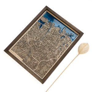 Peut inclure: Une carte en bois de Semarang, en Indonésie, avec un incrustation de résine bleue, encadrée dans un cadre en bois foncé.