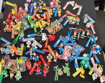 May include: A collection of colorful keychains featuring various cartoon characters, including Stitch, Mario, and Mickey Mouse. The keychains are made of soft, pliable plastic and have a variety of colors and designs.