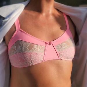 Peut inclure: Un soutien-gorge en dentelle rose avec une superposition de dentelle blanche. Le soutien-gorge a un délicat nœud au centre et des bretelles réglables.