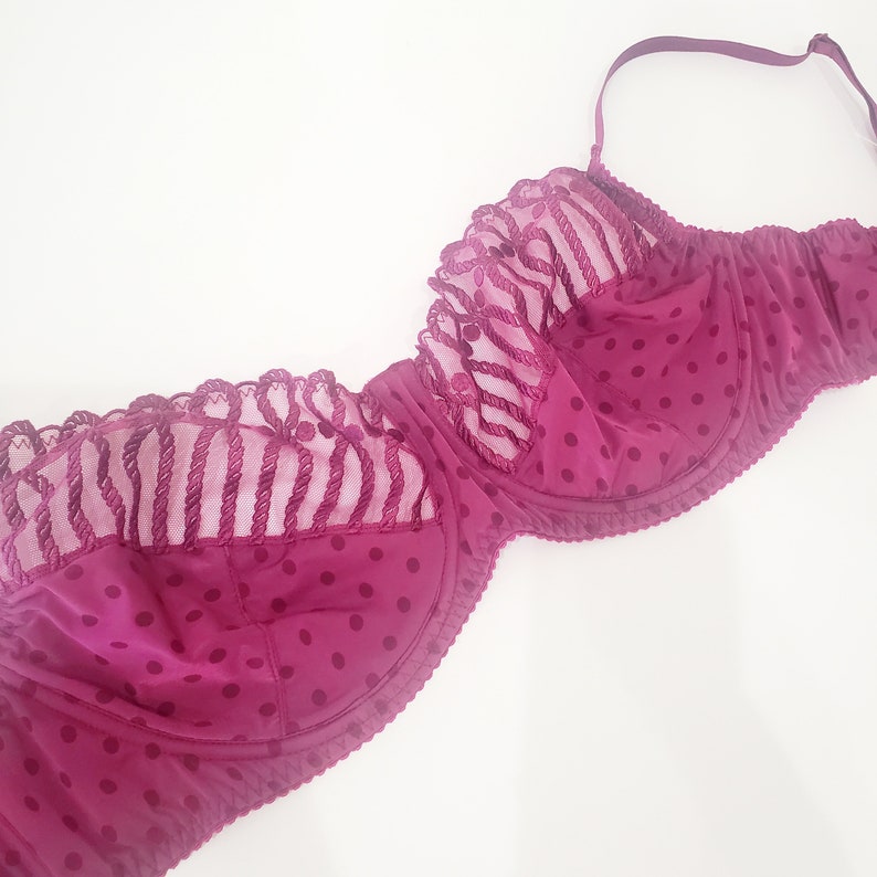 May include: A burgundy lace bra with polka dots. The bra has a delicate lace trim and adjustable straps.