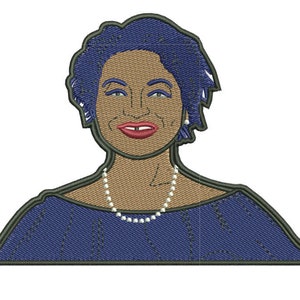May include: Embroidered illustration of a woman with short blue hair, wearing a navy blue dress and a pearl necklace.