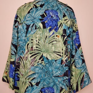 May include: A black silk shirt with a tropical print featuring large green leaves and blue flowers.