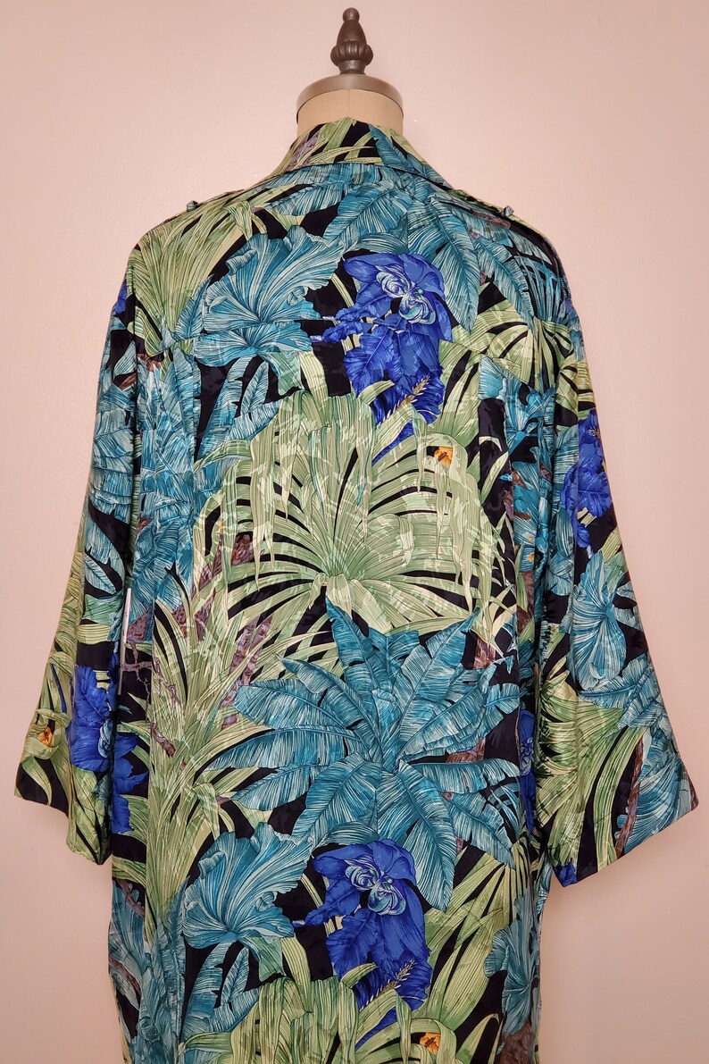 May include: A black silk shirt with a tropical print featuring large green leaves and blue flowers.