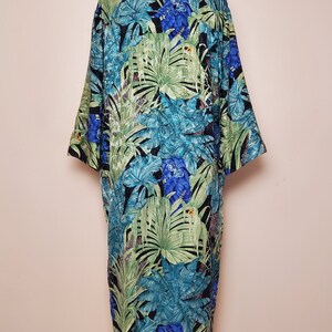 May include: A long, black, green, and blue tropical print robe with a button-up front.