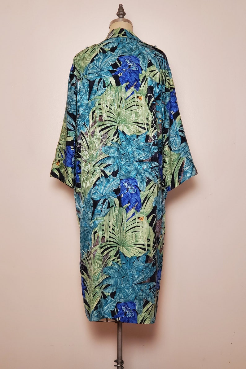 May include: A long, black, green, and blue tropical print robe with a button-up front.