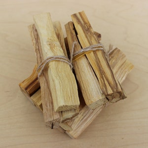 May include: A bundle of dried Palo Santo sticks tied together with twine. The sticks are light brown and have a natural wood grain.