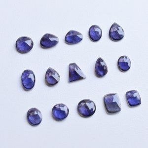 Peut inclure: Une collection de 14 pierres précieuses d'améthyste facettées de différentes formes et tailles, notamment ovales, en forme de poire et carrées. Les pierres précieuses sont d'une couleur violet foncé et ont une finition brillante et polie.