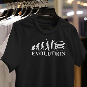 May include: Black t-shirt featuring a white graphic of the evolution of man culminating in a car. The text "EVOLUTION" is displayed beneath the graphic.