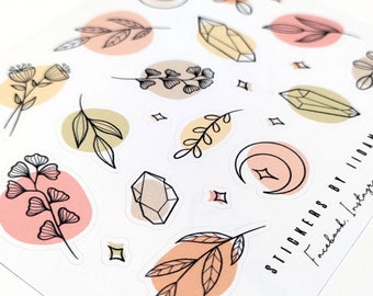 Op de afbeelding: Een vel stickers met verschillende illustraties van kristallen, bladeren en manen. De stickers zijn in tinten roze, geel en groen. De tekst "STICKERS BY LILLIAN Facebook | Instagram" is afgedrukt in de rechterbenedenhoek.