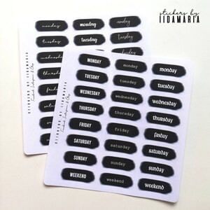 Op de afbeelding: Een set zwarte en witte stickers met de dagen van de week en het woord "weekend" erop. De stickers hebben een afgeronde rechthoekige vorm en een witte achtergrond.