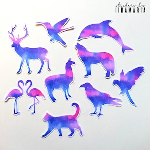 以下が含まれることがあります： ピンクとブルーの銀河のようなデザインの、様々な動物をモチーフにした、カラフルな水彩ステッカー10枚セット。シカ、ハチドリ、イルカ、オオカミ、ラマ、フラミンゴ、カラス、猫、オウムなどがあります。