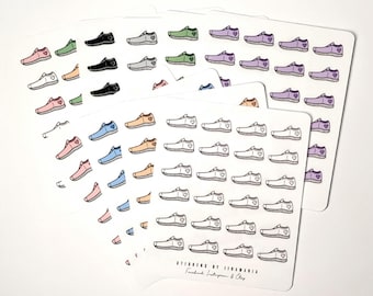 Op de afbeelding: Een vel met stickers met verschillende gekleurde sneakers met een klein hartje op elk. De stickers zijn gerangschikt in rijen en kolommen op een witte achtergrond. De tekst "Stickers by Vivanna" staat onderaan het vel.
