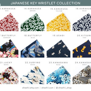 May include: A collection of 10 Japanese key wristlets featuring various designs, including red, green, yellow, and blue karakusa patterns, butterfly garden, blue butterfly, usagi, kitsune fox, lucky neko, surfing neko, and blue and grey kanagawa wave patterns.