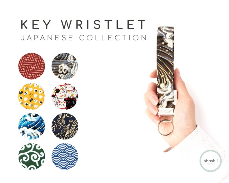 May include: Key wristlet with a Japanese wave pattern. The wristlet is made of fabric and has a silver metal key ring. The wristlet is shown against a white background.