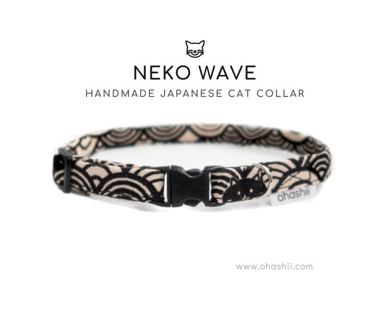 May include: A handmade Japanese cat collar with a black and beige wave pattern. The collar has a black plastic buckle and the text "NEKO WAVE HANDMADE JAPANESE CAT COLLAR". The brand name "ohashii" is also visible.