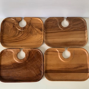 May include: Set of four wooden serving trays with a cutout for a wine glass. The trays are made of light brown wood and have a rectangular shape.