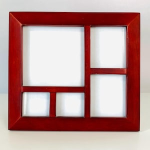 May include: A rectangular wooden photo frame with a deep reddish-brown finish. The frame features five distinct openings of varying sizes, arranged with one large square section on the left and four smaller rectangular sections on the right.